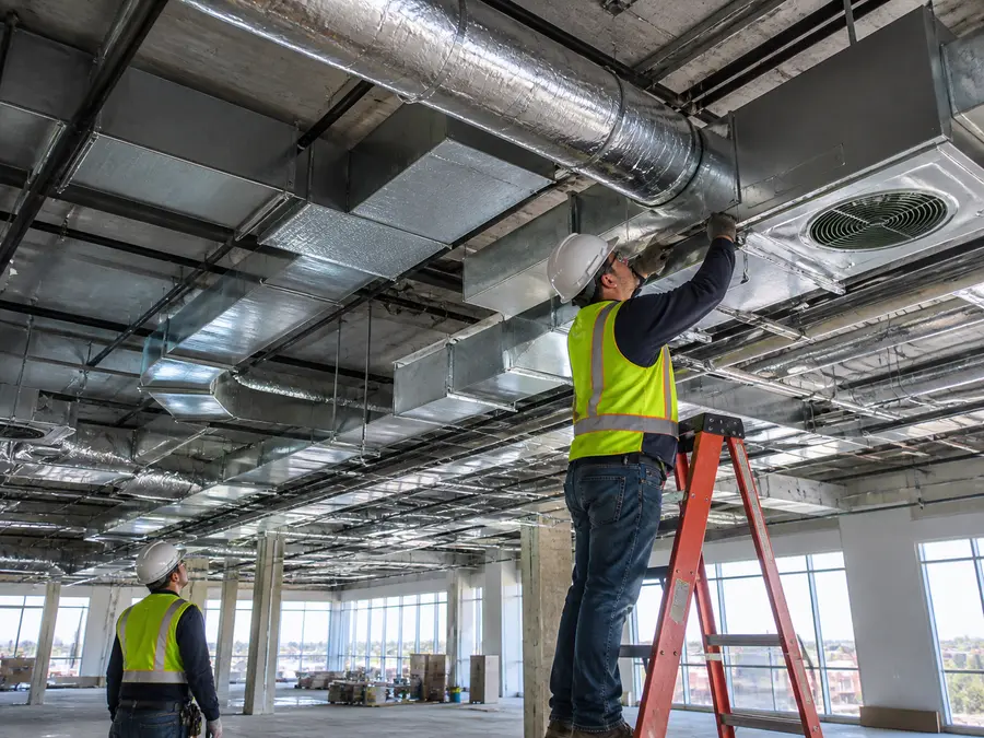 SWC Builders technician inspecting mechanical systems and ductwork inside a commercial building