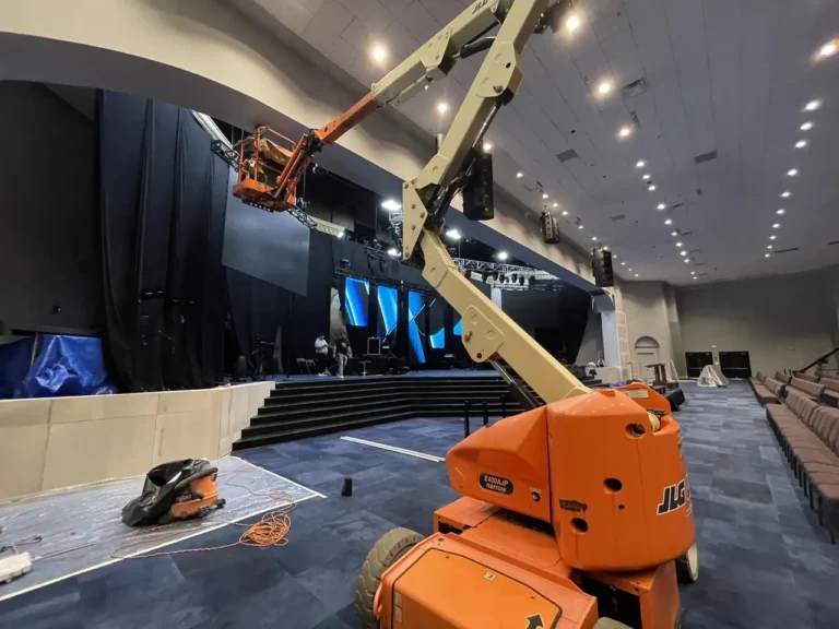 Detailed look at the stage area with rigging, framing, and equipment for the church's audio-visual systems.